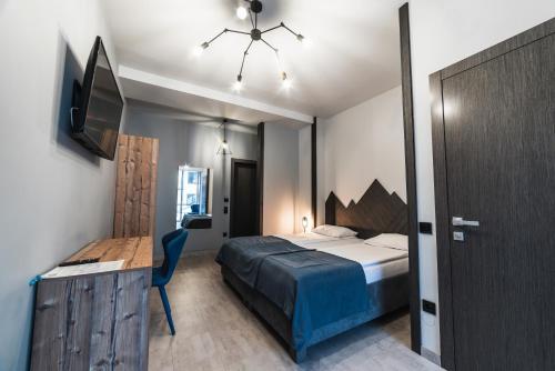 a bedroom with a bed and a desk and a tv at Синя гора in Bukovel