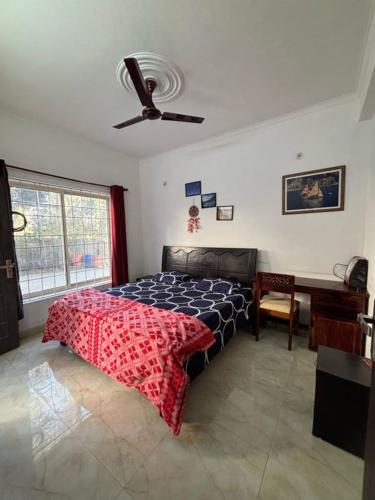 a bedroom with a bed and a ceiling fan at Ekaant Homestay in Bhowāli