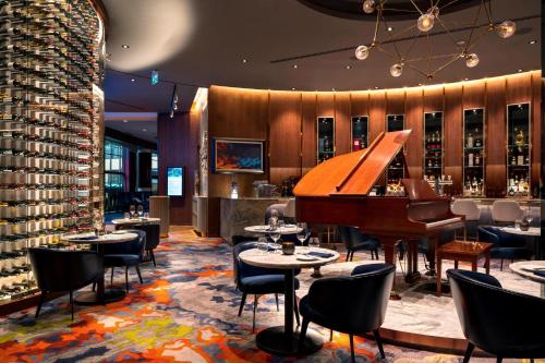 a restaurant with a piano and tables and chairs at Delta Hotels by Marriott Burnaby Conference Centre in Burnaby