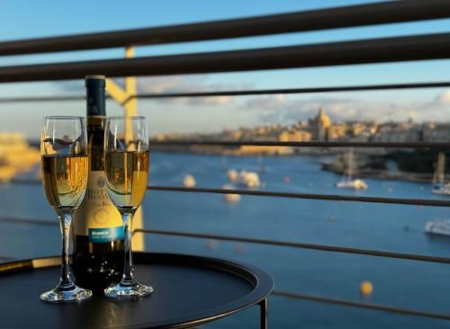 two glasses of wine on a table with a view at Jacuzzi Terrace Getaway with Valletta Views in Sliema
