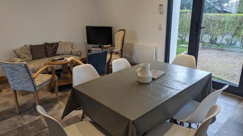 a dining room with a table and chairs at L'idylle - maison a la mer in Quiberville