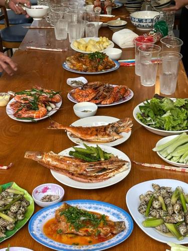 a table with many plates of food on it at Hide Away Bungalows in Ben Tre City in Ben Tre