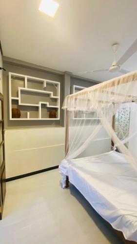 a bedroom with a bed with a mosquito net at Hasi Villa in Ahangama