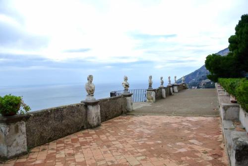 a walkway with statues on it next to the ocean at B&B Oliva in Scala