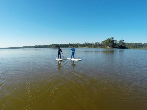 two people are paddle boarding on a lake at Ticket2Surf in Palheiros da Tocha