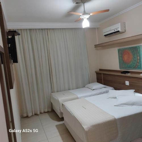 a hotel room with two beds and a ceiling fan at Prince Hotel in Ribeirão Preto