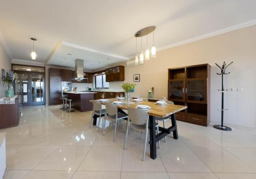a kitchen and dining room with a table and chairs at Jacuzzi Terrace Getaway with Valletta Views in Sliema
