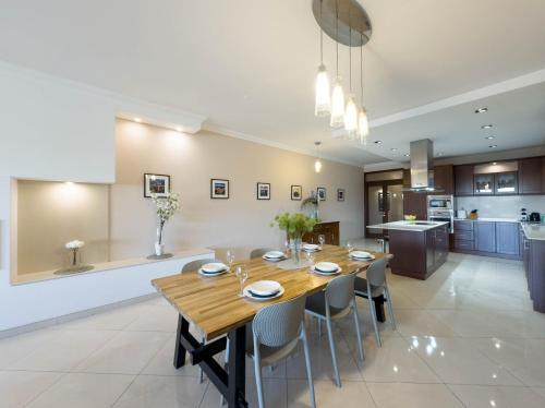 a kitchen and dining room with a wooden table and chairs at Jacuzzi Terrace Getaway with Valletta Views in Sliema