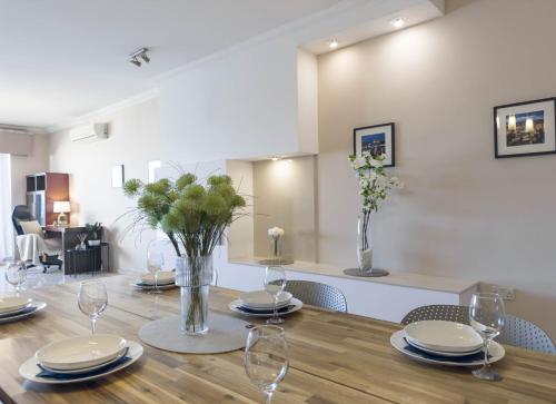 a dining room with a table with plates and wine glasses at Jacuzzi Terrace Getaway with Valletta Views in Sliema