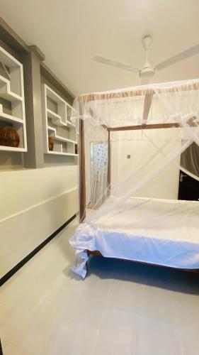 a bedroom with a bed with a white bed frame at Hasi Villa in Ahangama