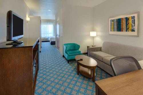 a living room with a couch and a flat screen tv at Fairfield Inn & Suites by Marriott San Francisco Airport in Millbrae