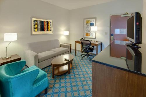 a living room with a couch and a tv at Fairfield Inn & Suites by Marriott San Francisco Airport in Millbrae
