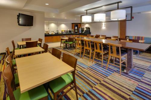 a dining room with wooden tables and chairs at Fairfield Inn & Suites by Marriott San Francisco Airport in Millbrae