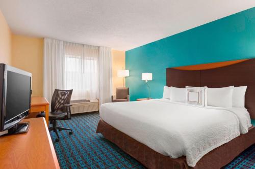a hotel room with a large bed and a flat screen tv at Fairfield Inn & Suites by Marriott Mankato in Mankato