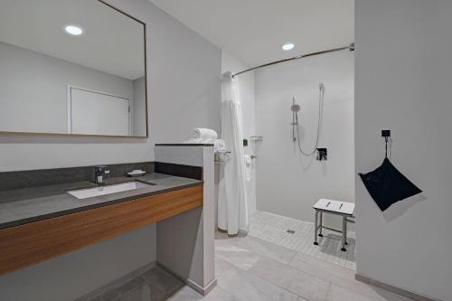 a white bathroom with a shower and a sink at Fairfield Inn & Suites by Marriott Milwaukee Brookfield in Brookfield
