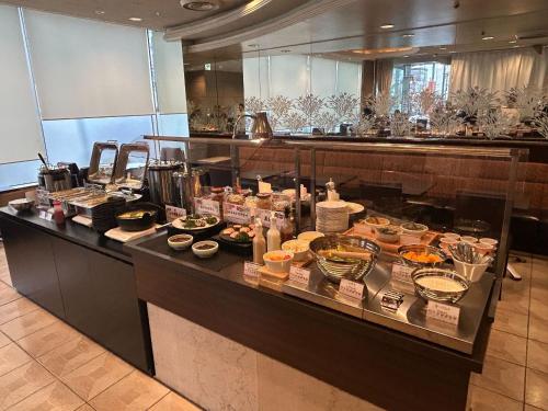 a buffet line in a restaurant with food on it at APA Hotel Takaoka Marunouchi in Takaoka