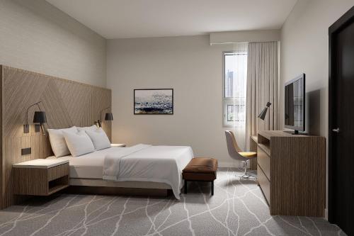 a hotel room with a bed and a television at Delta Hotels by Marriott Grande Prairie Airport in Grande Prairie