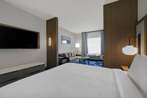 a hotel room with a bed and a television at Fairfield Inn & Suites by Marriott Milwaukee Brookfield in Brookfield