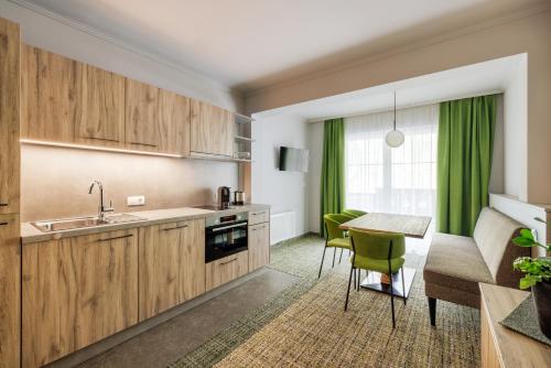 a kitchen with wooden cabinets and a table with green chairs at Alpenaussicht in Obergurgl