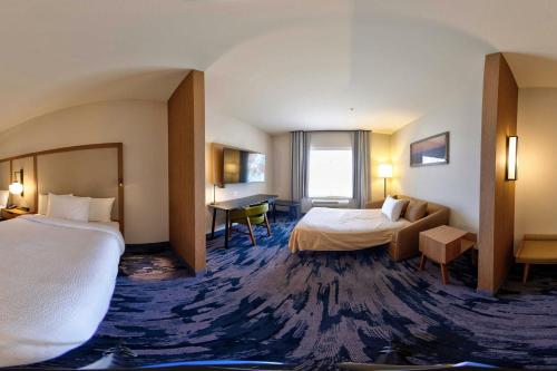 a hotel room with two beds and a desk at Fairfield Inn & Suites by Marriott Milwaukee Brookfield in Brookfield