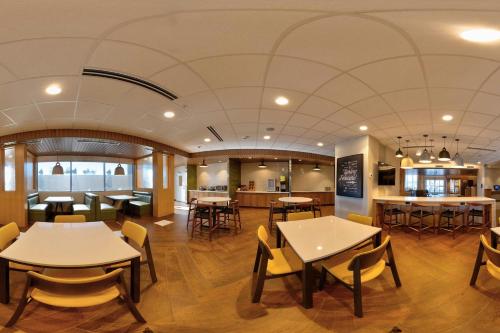 a restaurant with tables and chairs and a bar at Fairfield Inn & Suites by Marriott Milwaukee Brookfield in Brookfield