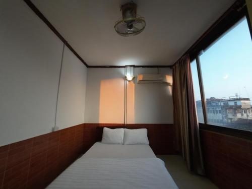a bed in a room with a large window at Intouch Guest House in Vientiane
