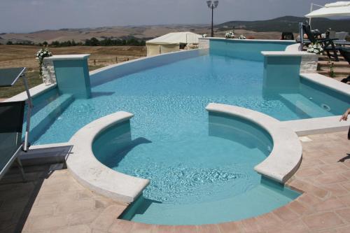 a large swimming pool with blue water at Agriturismo Il Macchione in Pienza