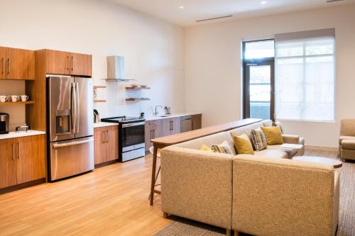 a living room with a couch and a kitchen at Element Scottsdale at SkySong in Scottsdale