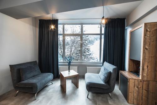 a living room with two chairs and a television at Синя гора in Bukovel
