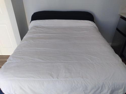 a bed with white sheets and a black blanket at Homes for Soul Los Angeles in Los Angeles