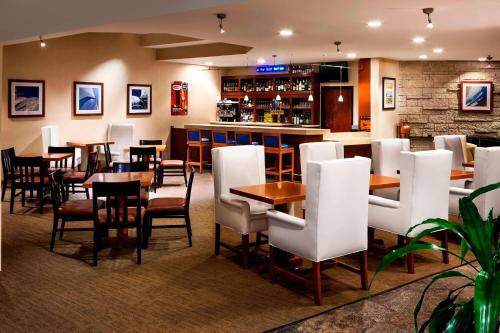 a restaurant with tables and chairs and a bar at Four Points by Sheraton Ventura Harbor Resort in Ventura