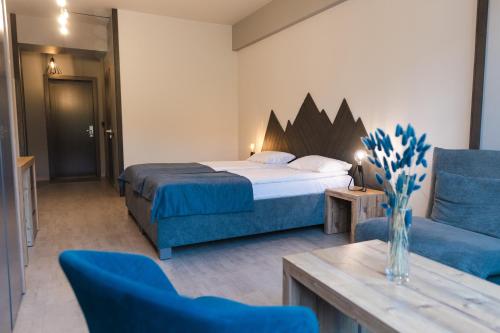a hotel room with a bed and a blue chair at Синя гора in Bukovel