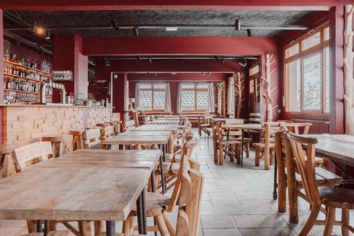 an empty restaurant with wooden tables and chairs at ho36 Les Menuires in Les Menuires