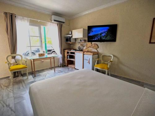 a bedroom with a bed and a tv on the wall at Gibralfaro Alojamiento Turístico cerca de la playa in Málaga