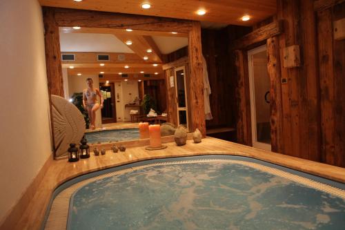 a jacuzzi tub in a house with a woman in the mirror at Hotel Petit Prince in Antagnod
