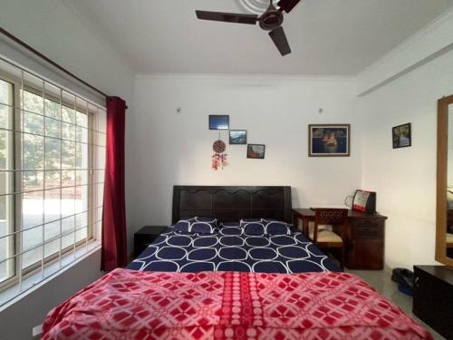 a bedroom with a bed and a ceiling fan at Ekaant Homestay in Bhowāli