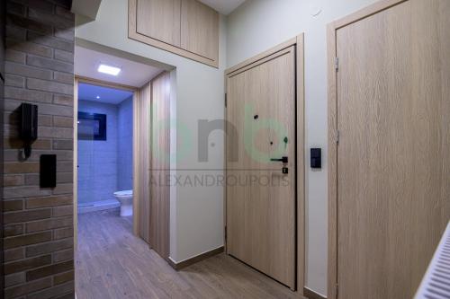 a bathroom with a toilet and a wooden door at Sea view luxury apartment in Alexandroupoli