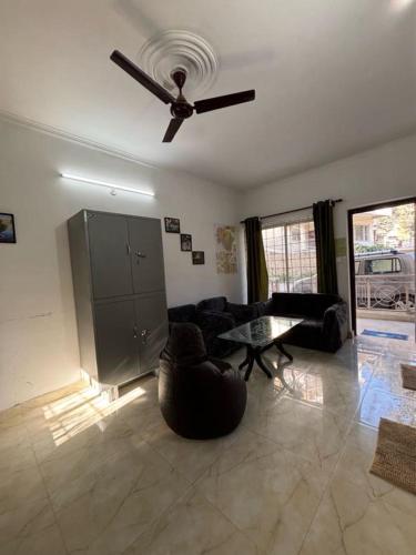 a living room with a ceiling fan and a couch at Ekaant Homestay in Bhowāli