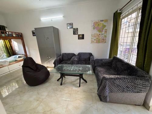 a living room with two couches and a table at Ekaant Homestay in Bhowāli