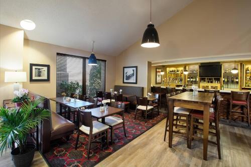 a restaurant with tables and chairs and a bar at Four Points by Sheraton Charlotte/Pineville in Charlotte