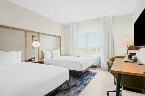 a hotel room with two beds and a desk at Fairfield Inn & Suites Fort Lauderdale Airport & Cruise Port in Dania Beach