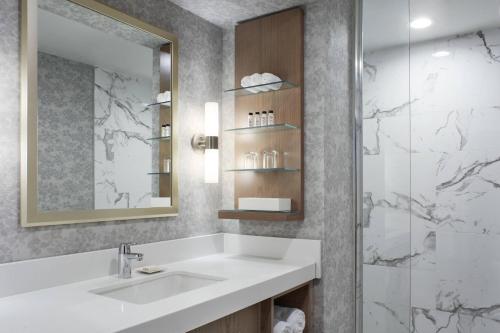 a bathroom with a sink and a shower at Delta Hotels by Marriott London Armouries in London