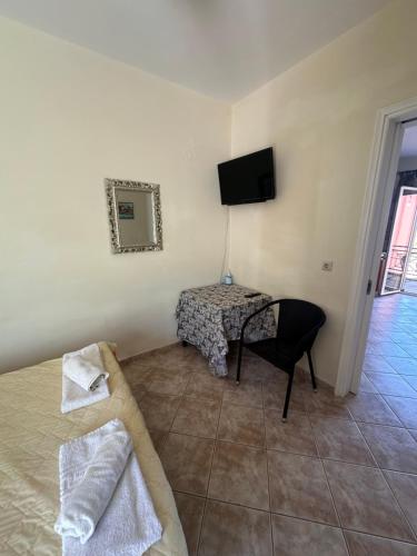 a bedroom with a bed and a table and a tv at Seapine Studios in Lassi