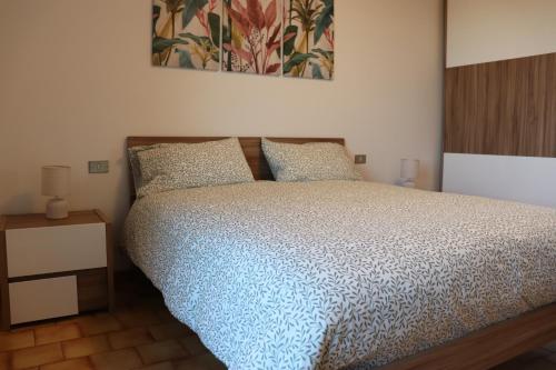 Un dormitorio con una cama y un cuadro en la pared. en La casa di Juliette, en Merone
