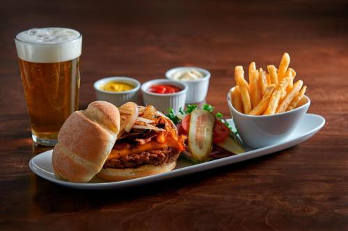 a plate with a sandwich and fries and a glass of beer at Element Toronto Airport in Mississauga