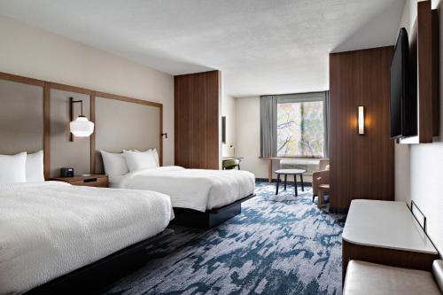 a hotel room with two beds and a window at Fairfield Inn & Suites by Marriott Fayetteville in Fayetteville