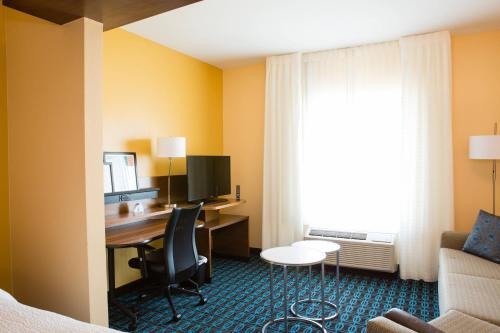 a hotel room with a desk and a bed and a couch at Fairfield Inn & Suites by Marriott Sheridan in Sheridan