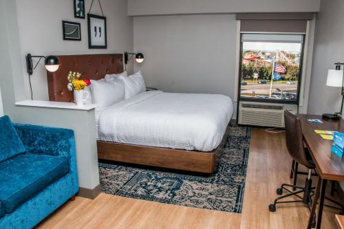 a hotel room with a bed and a blue couch at Four Points by Sheraton Allentown Lehigh Valley in Allentown