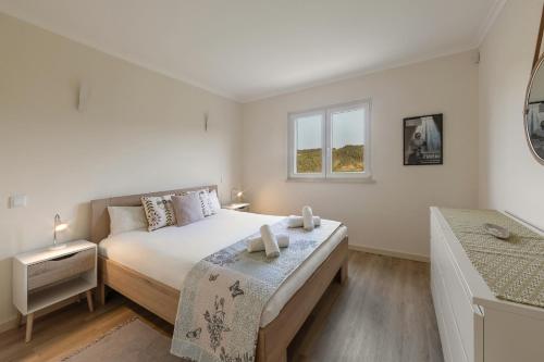 En eller flere senge i et værelse på Casa das Pêras