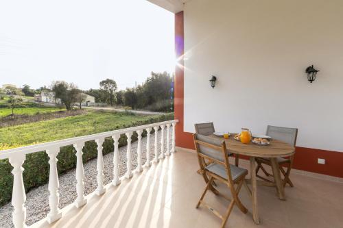 a table and chairs on a balcony with a view at Casa das Pêras in Óbidos